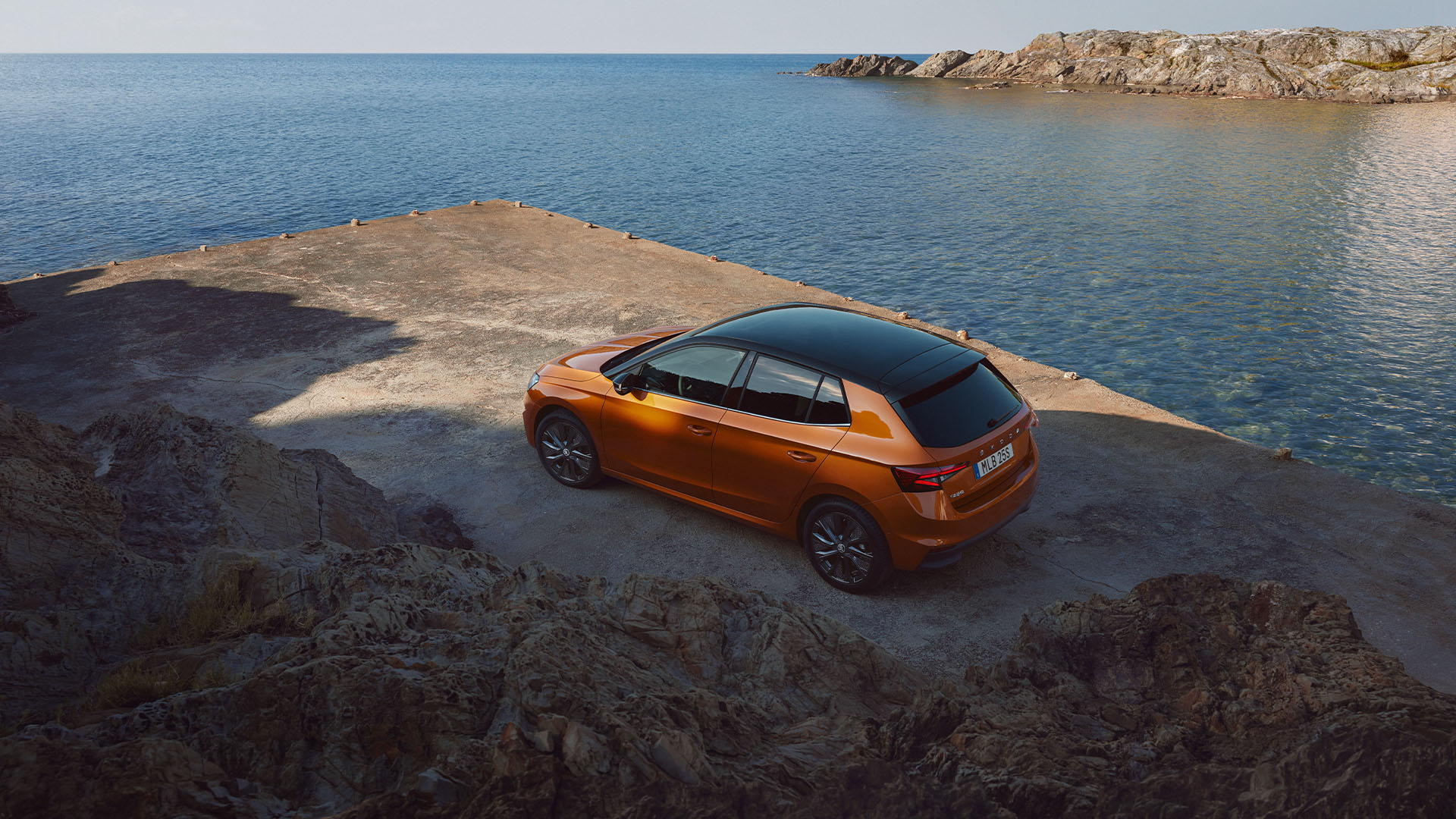 Orange Skoda Fabia vid vattnet